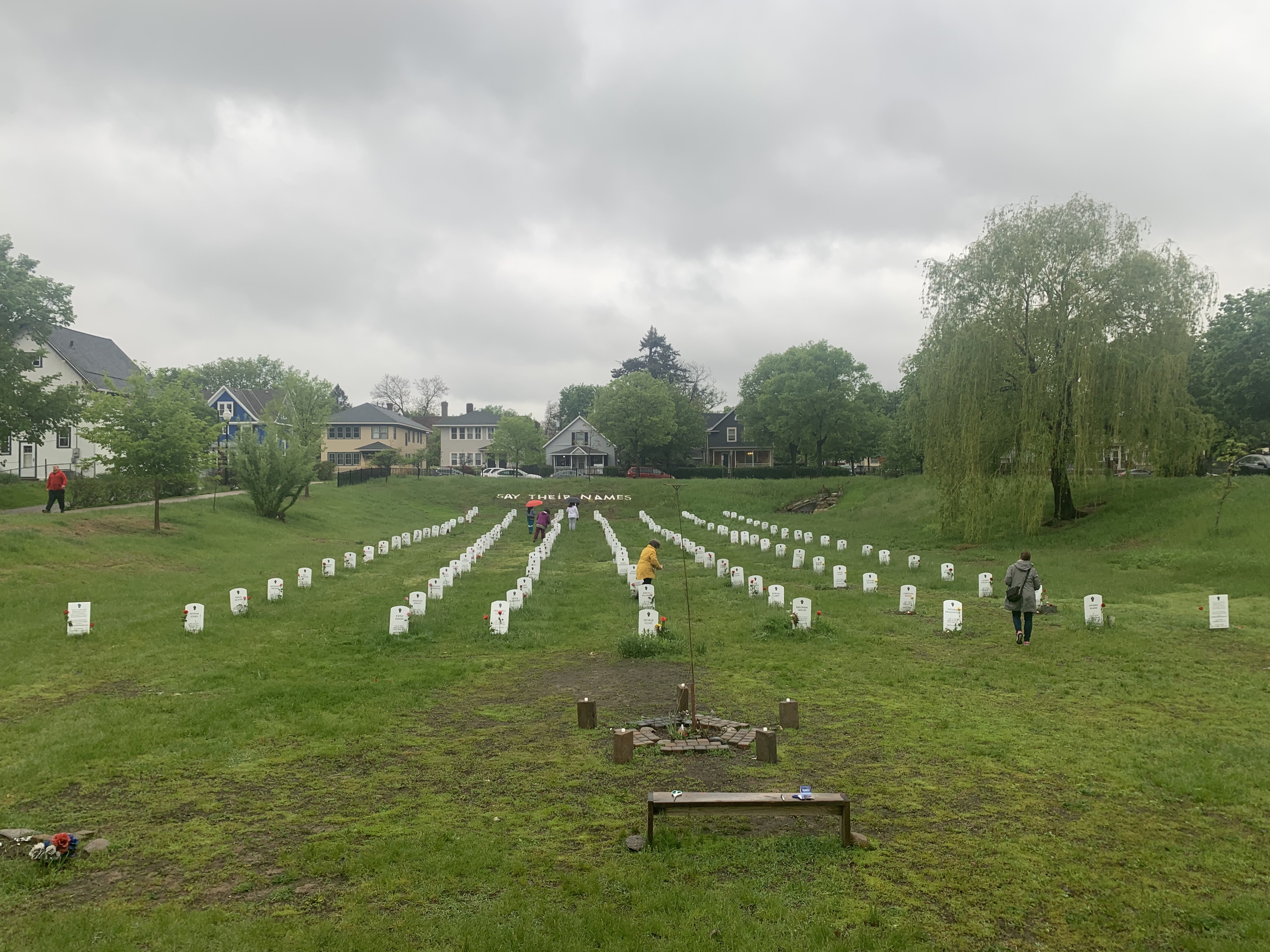 Volunteers lay flowers among the rows at a cemetary
