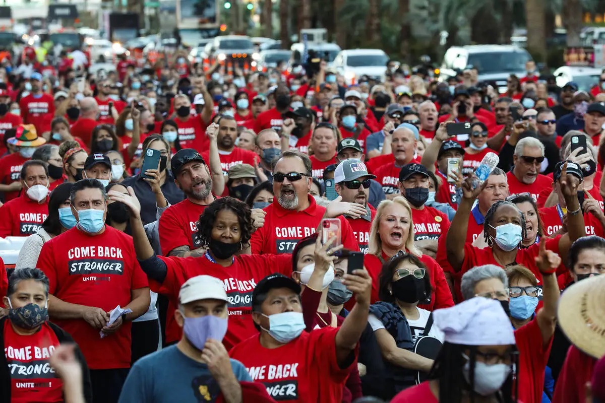 Group of protesters march dressed in red.