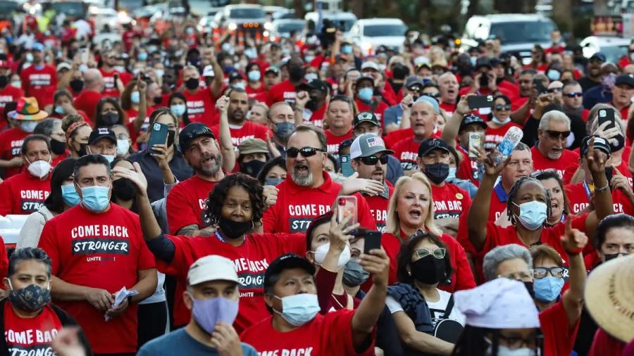 Group of protestors march in matching red shirts.