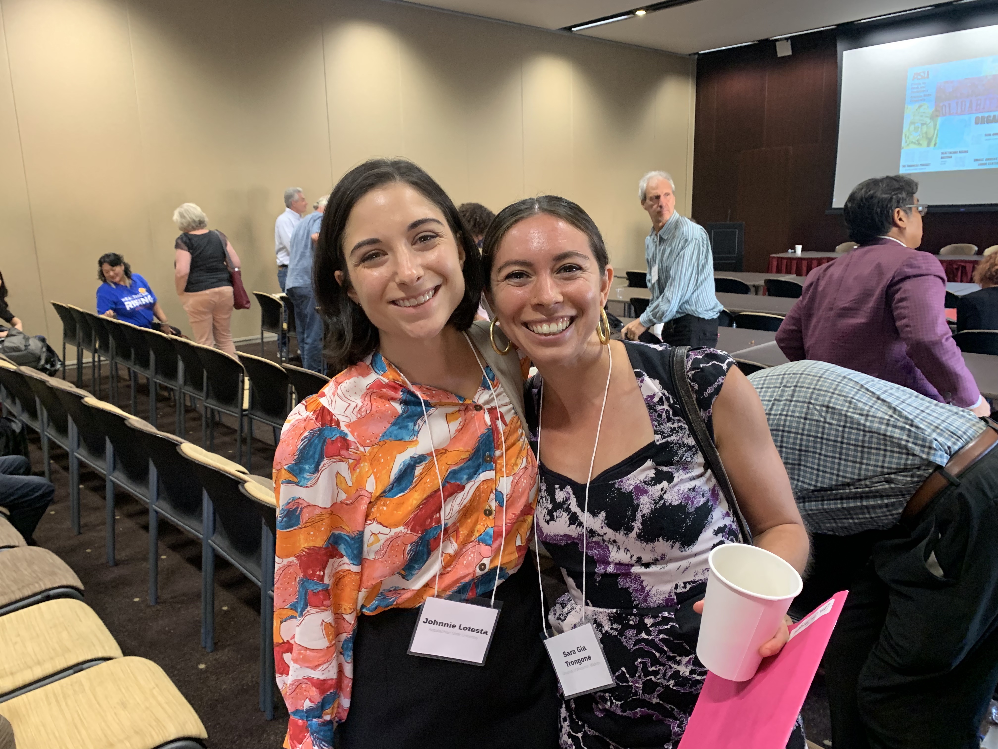 Two women smile and pose for the camera after the conference.