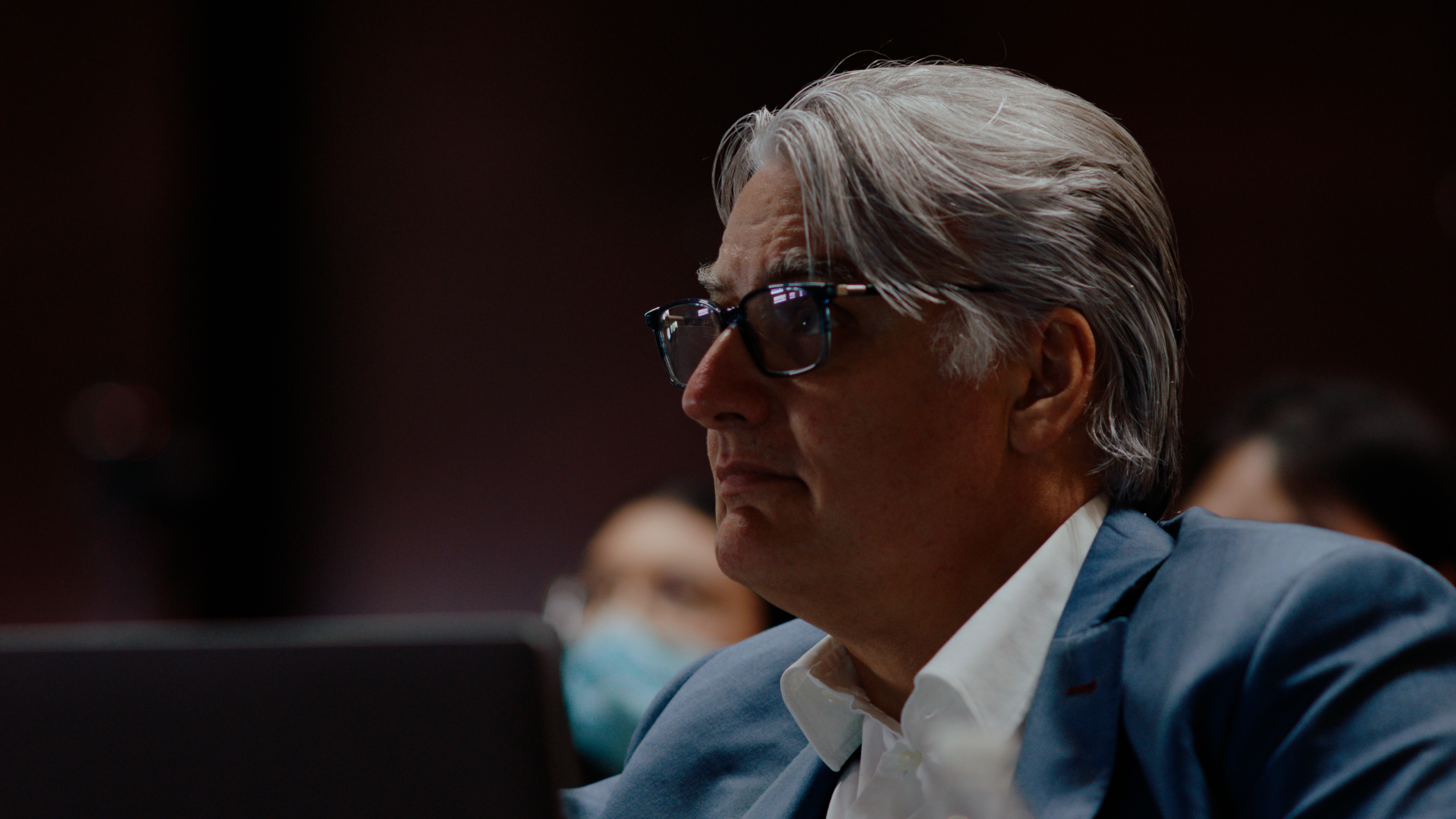 Michael McQuarrie watches a speaker from the crowd.