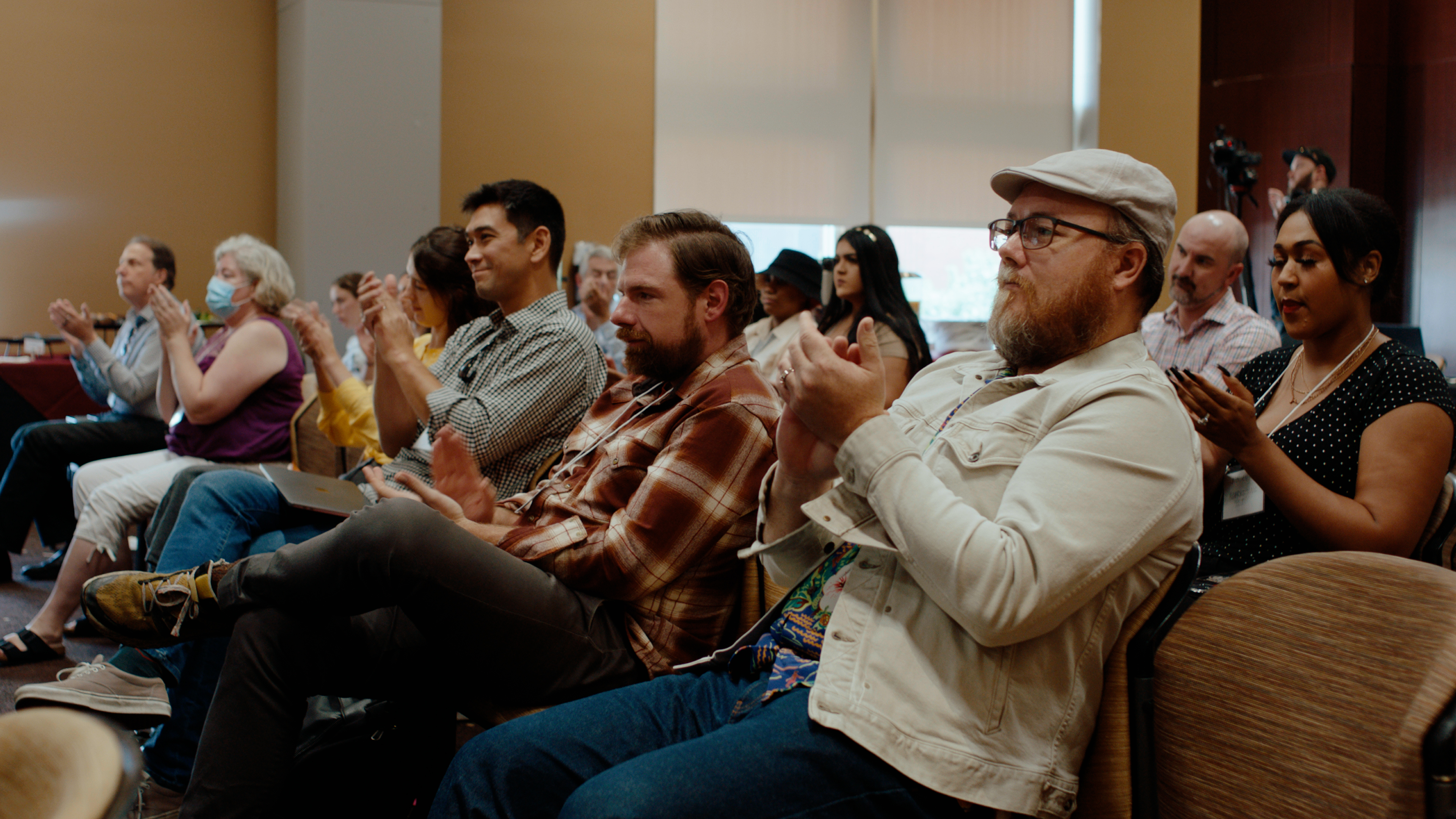 The crowd at the conference applauds.