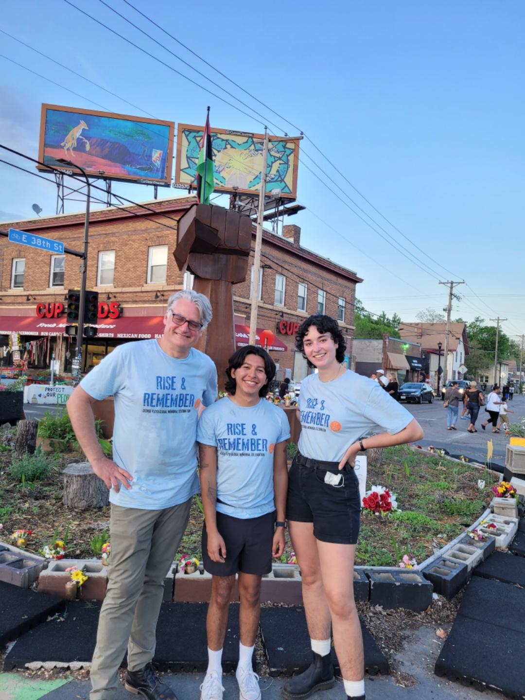 Three people posed in front of the fist at 38th and Chicago.