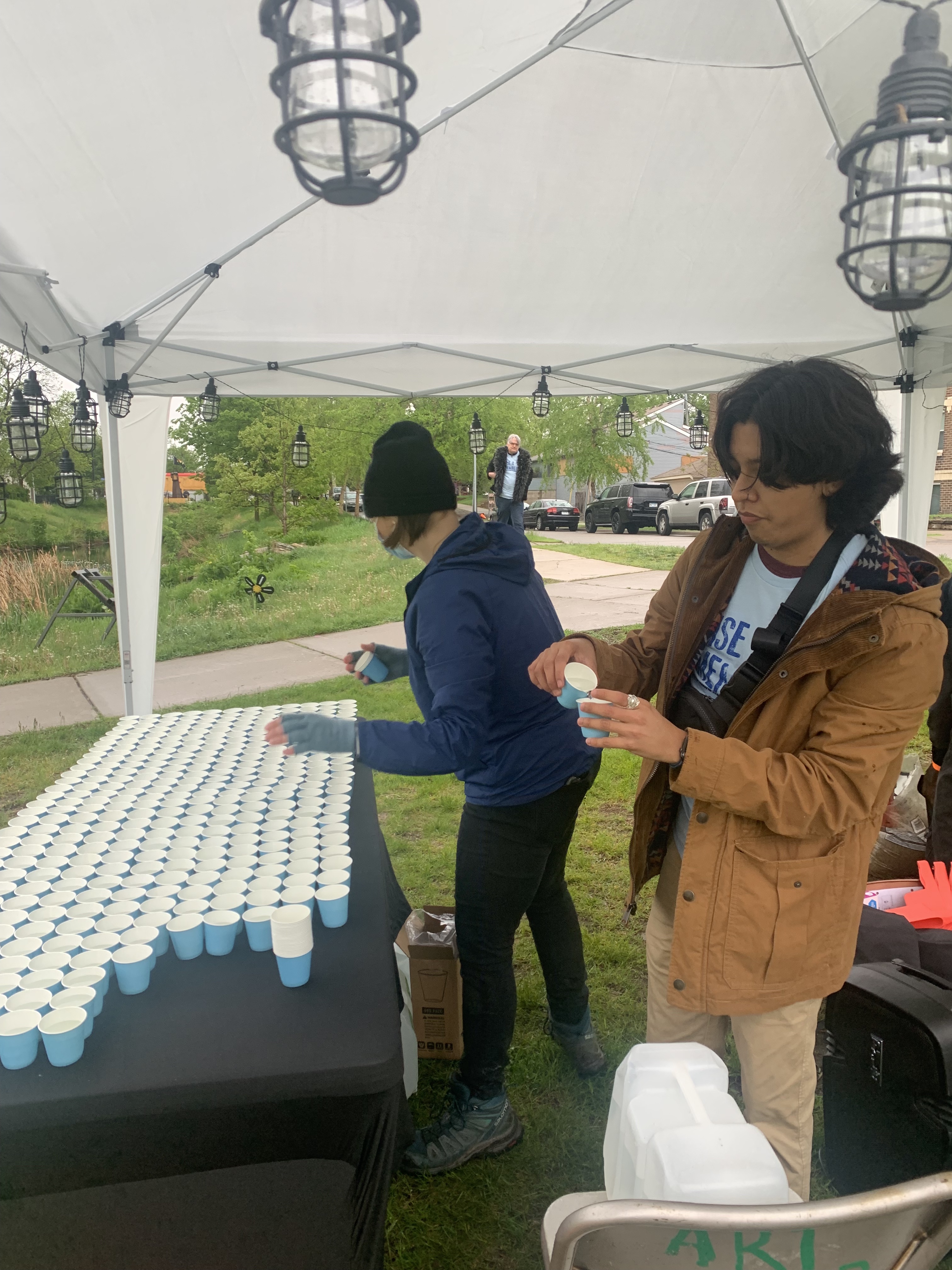 Young man fills cups with water.