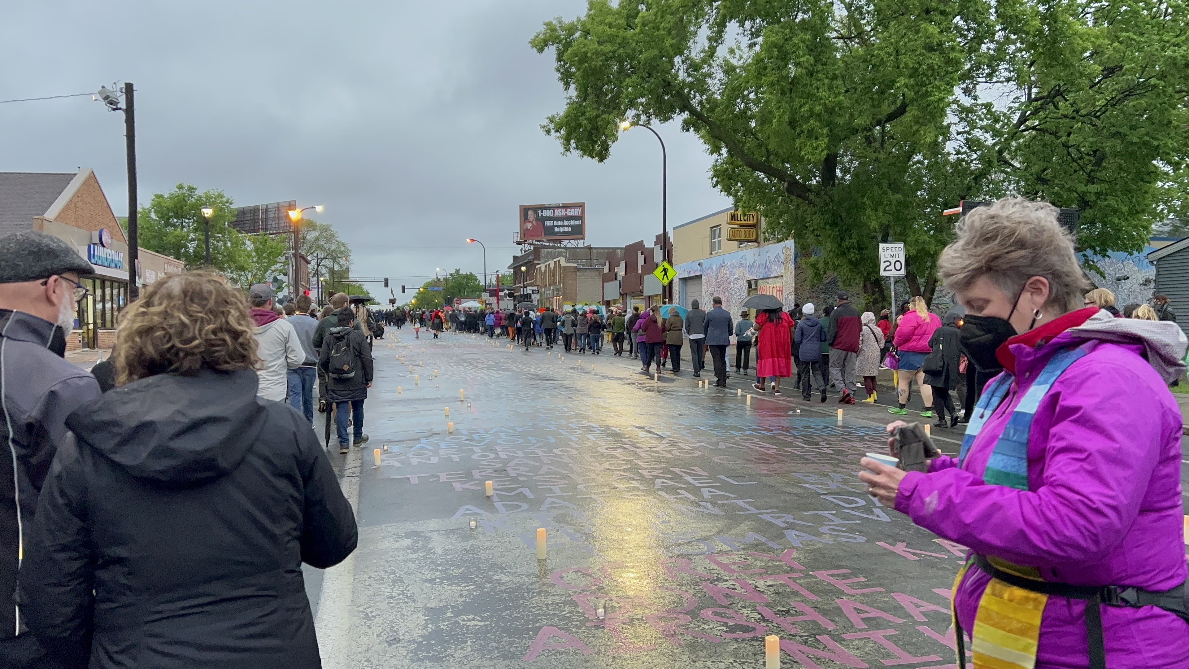 Candles line a street with names written upon it.