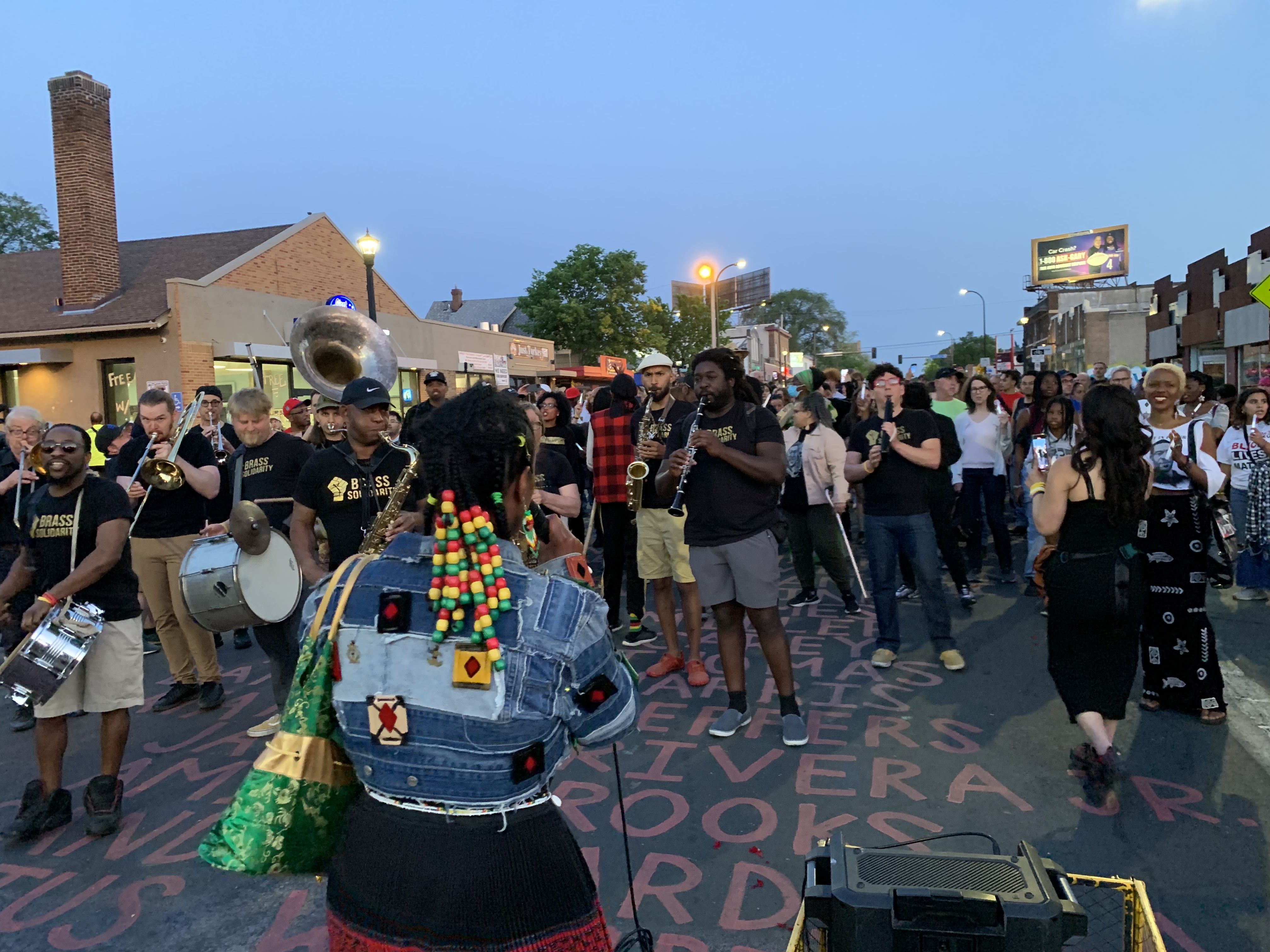 A marching band leads the procession down the mourning passage.