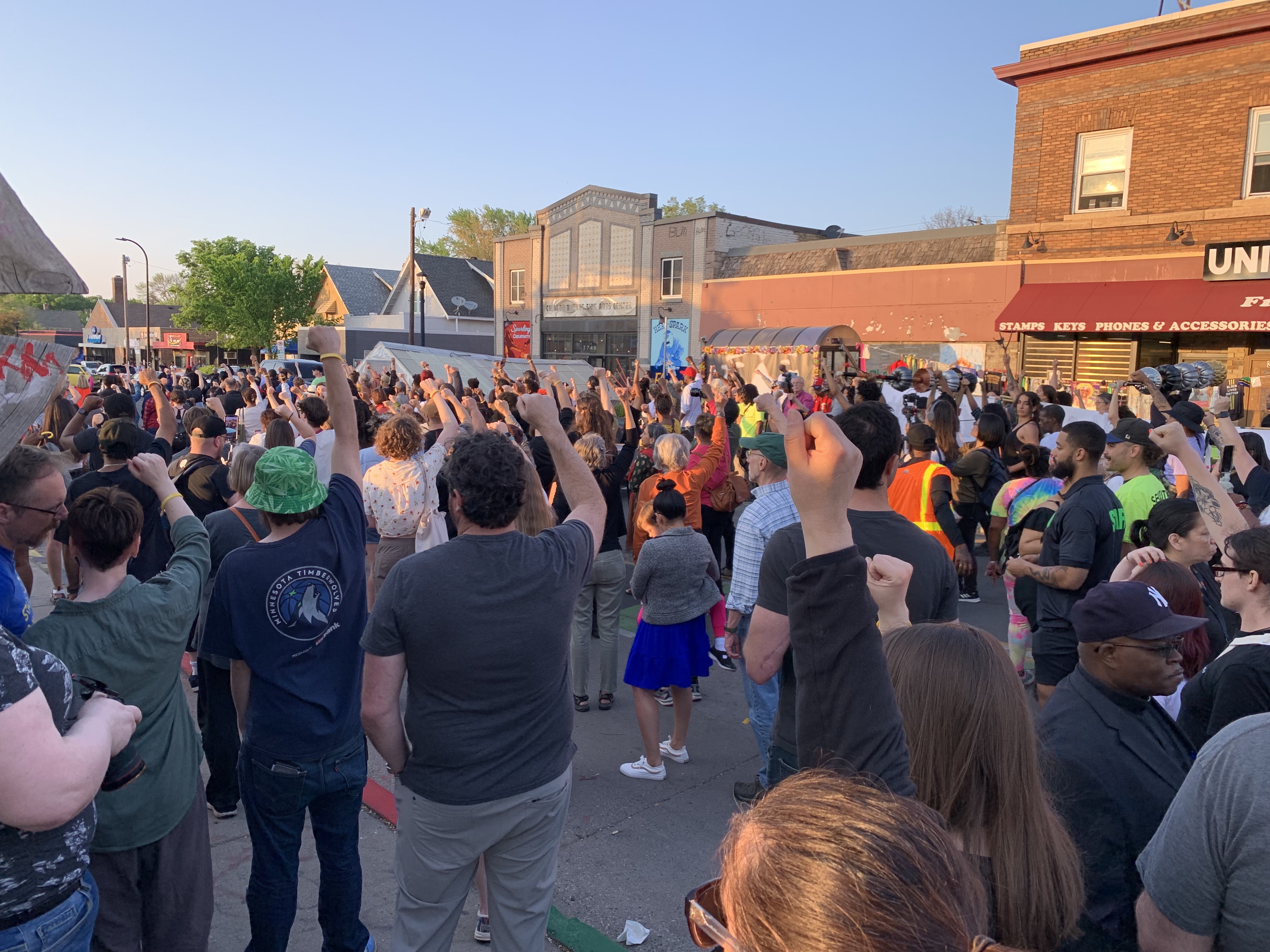 A crowd raises their fists.