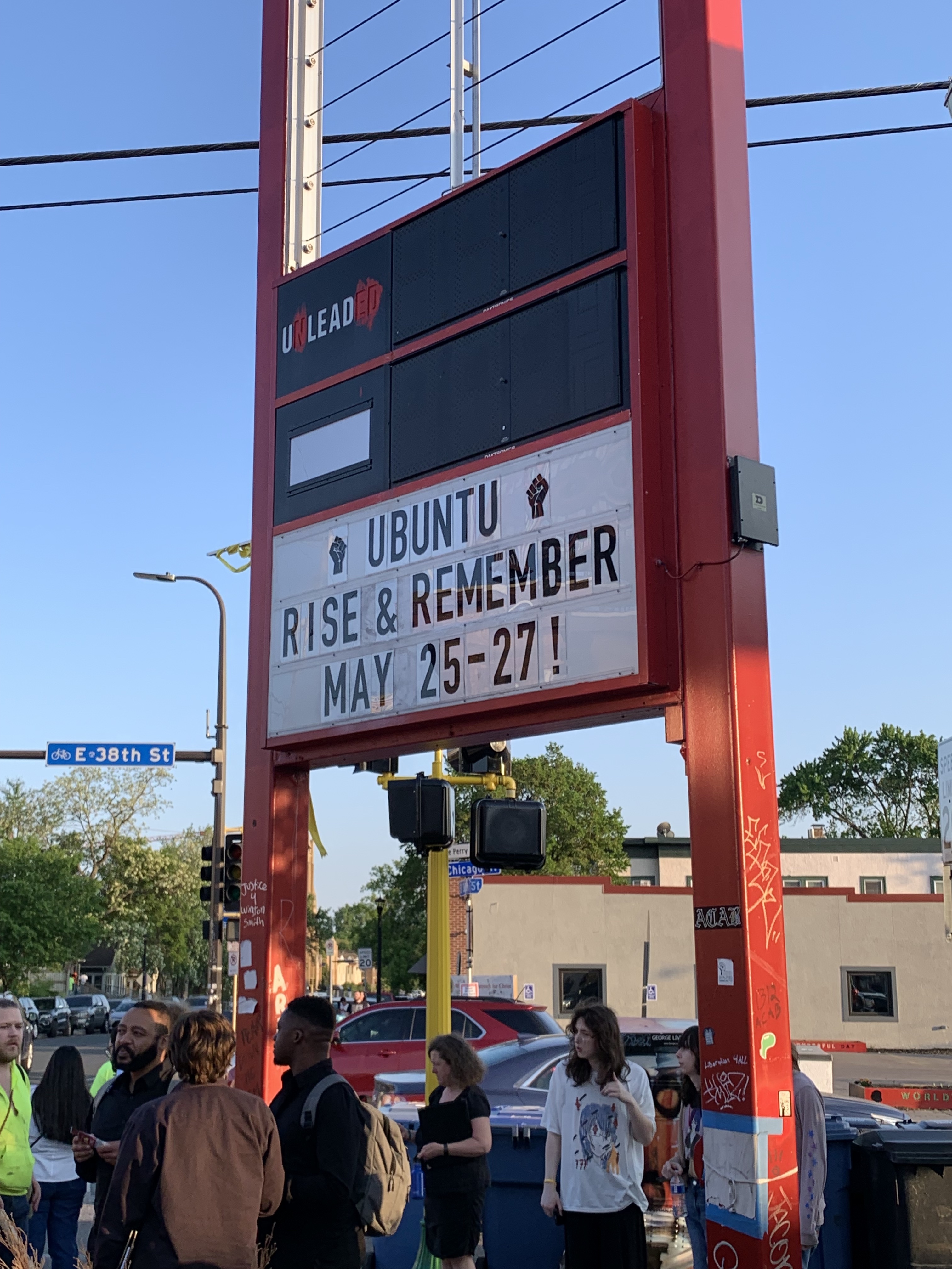 Sign reading "Ubuntu, Rise & Remember, May 25-27!"