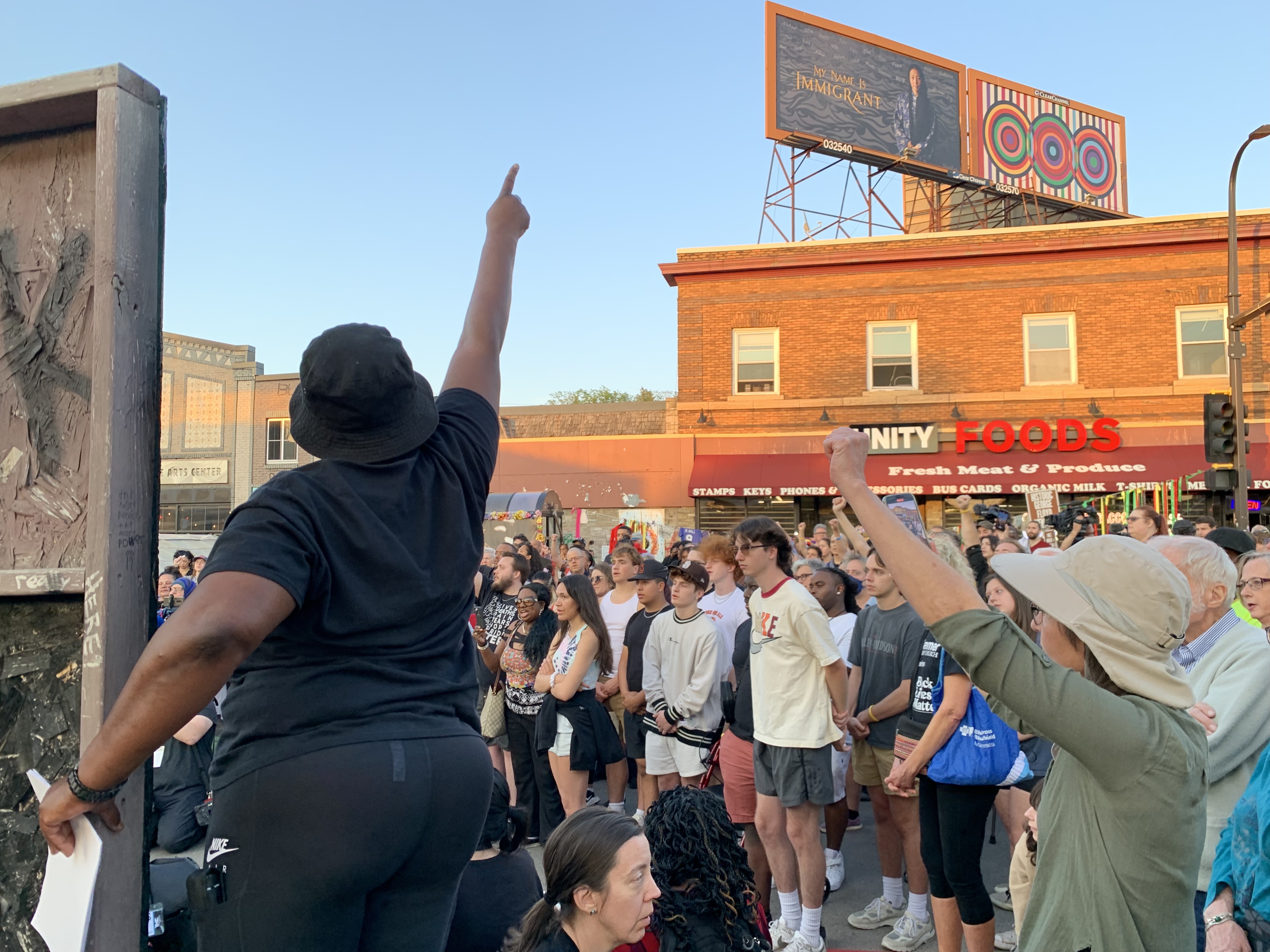 Woman points, rallying a crowd.