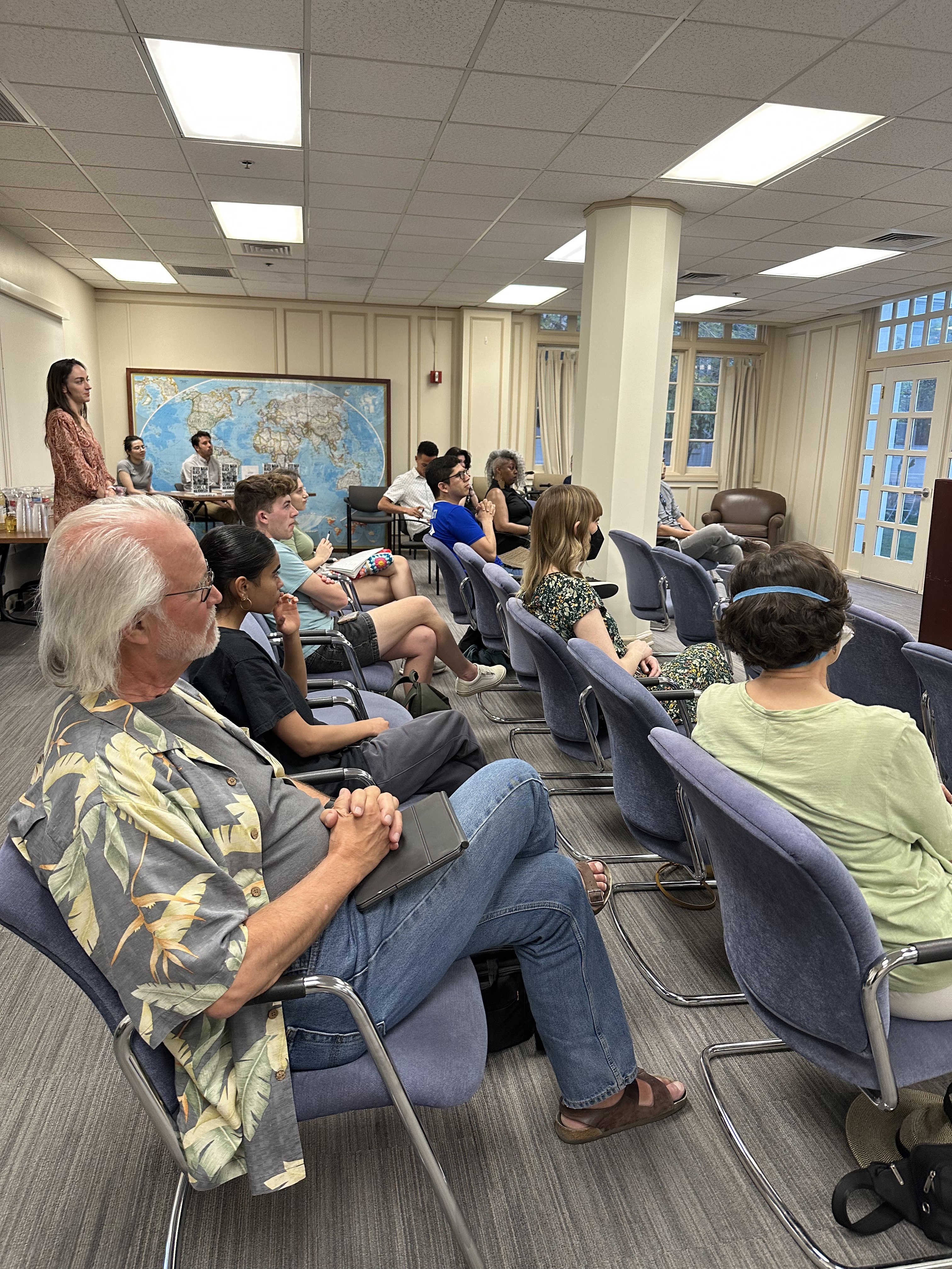 A seated crowd looks at the speaker.
